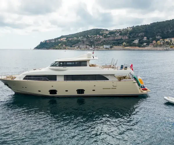 Luxury motor yacht Ferretti Custom Line Navetta 26 'La Pausa', anchored off the coast with a scenic hillside background.