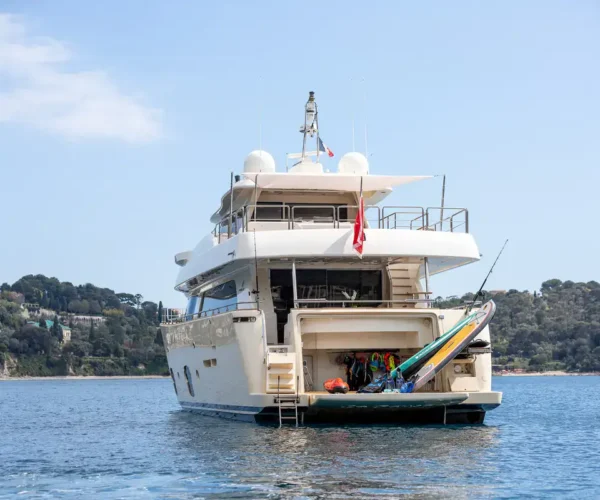 Luxury yacht Ferretti Custom Line Navetta 26 'La Pausa' with water sports equipment on bright sea background.