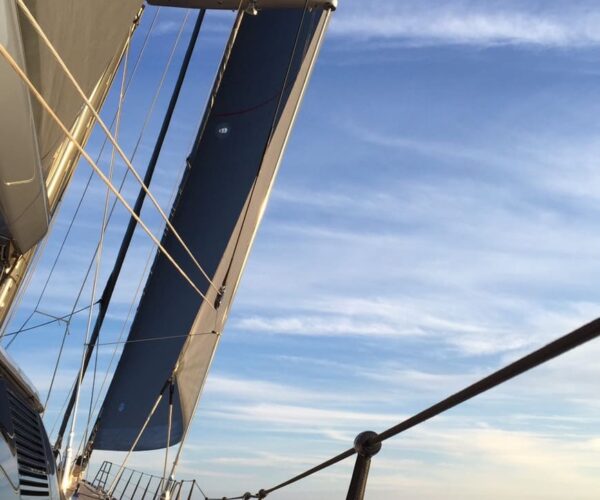 Close-up of yacht mast and rigging on open sea.