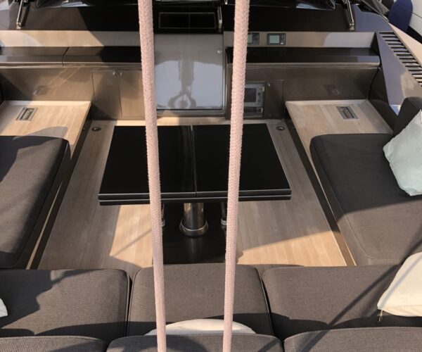 Interior view of a high-end yacht's helm station with seating and navigation equipment.