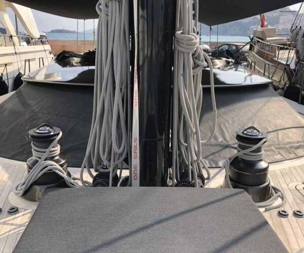 Close-up of yacht bow with rigging, mooring cleats, and deck details.