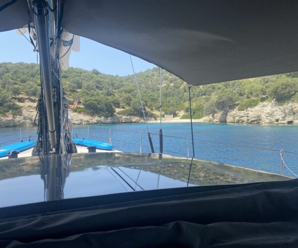 View from a luxury yacht showing the coastline and calm waters.