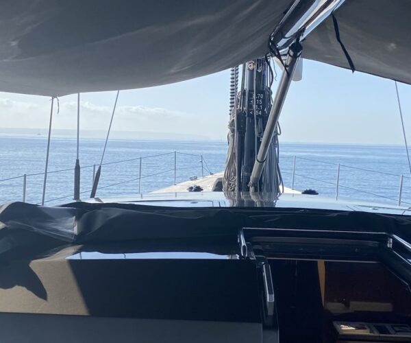 View from the yacht's helm showing the deck and ocean horizon.